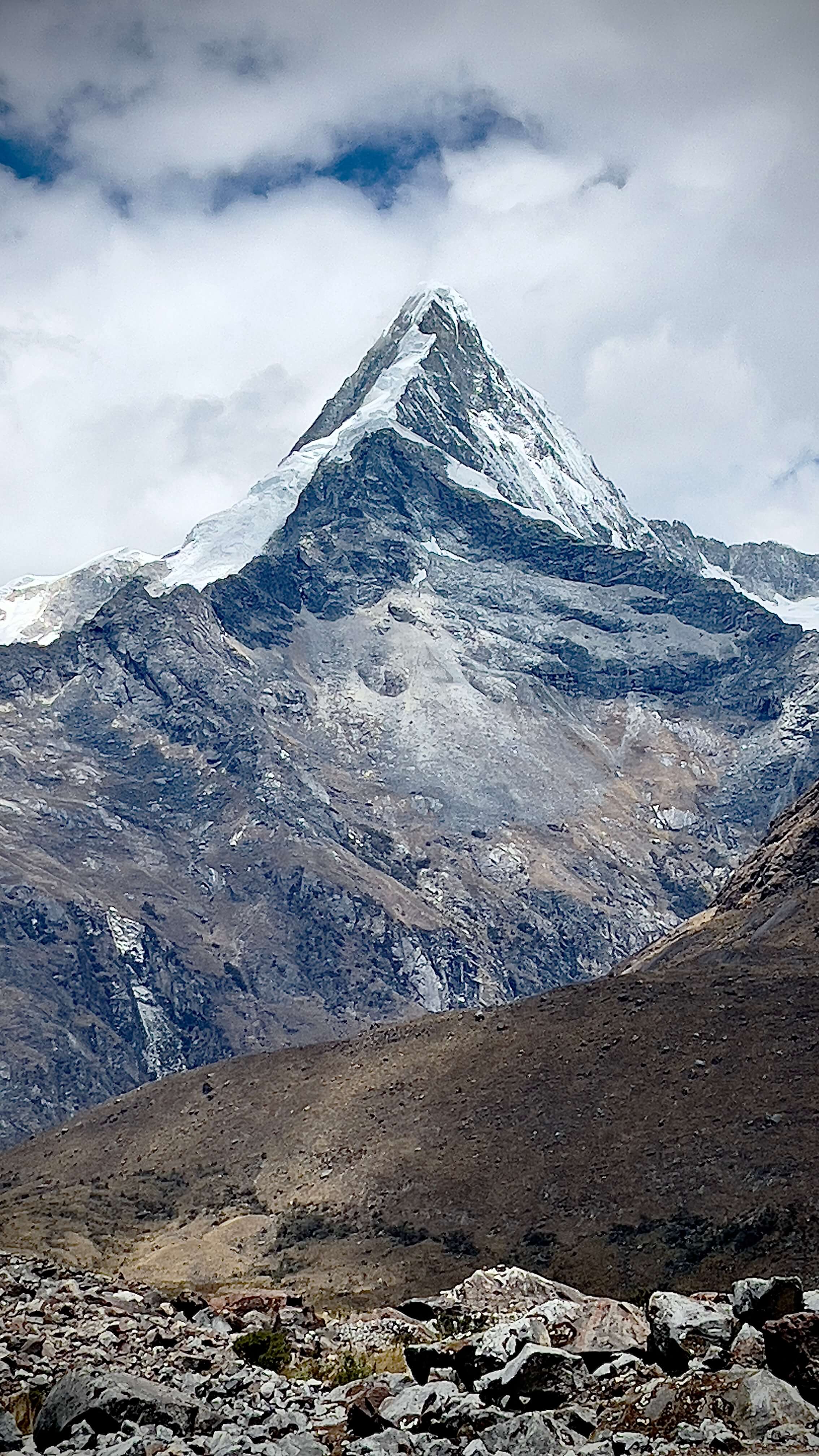 Majestic snow-capped mountain peak rising dramatically above rocky terrain