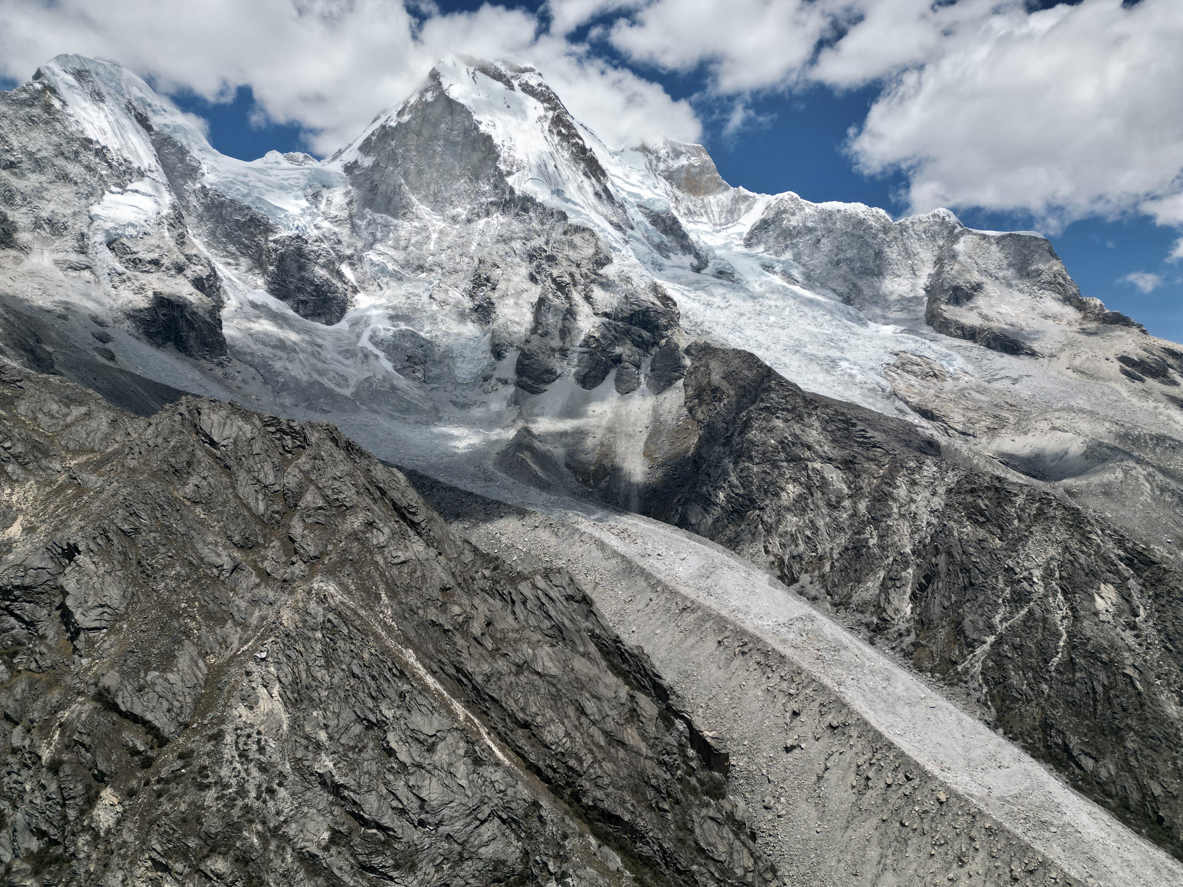 Dramatic snow-covered peaks and glaciers with rocky moraine landscape