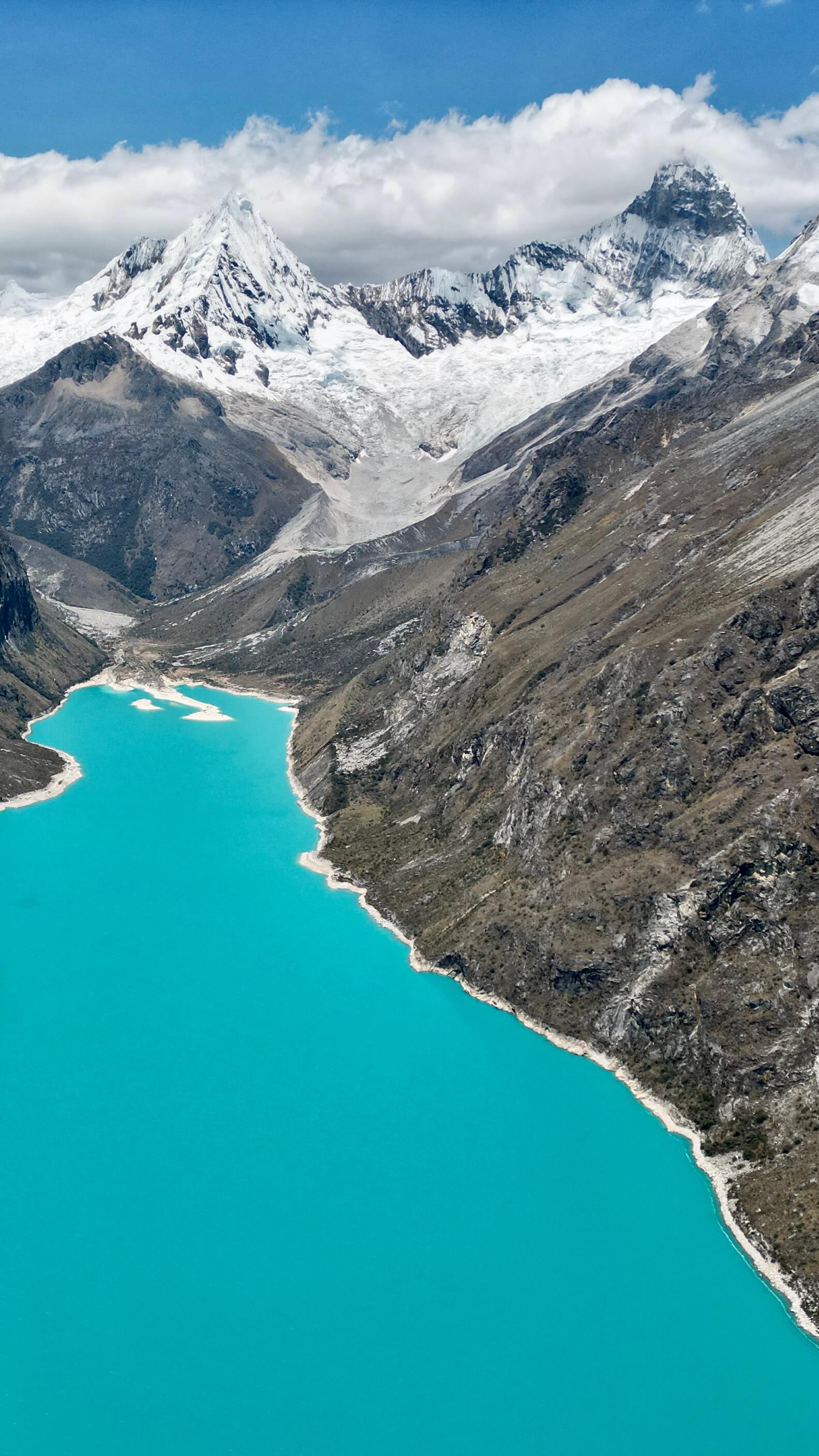 Stunning turquoise glacial lake surrounded by snow-capped Andean peaks