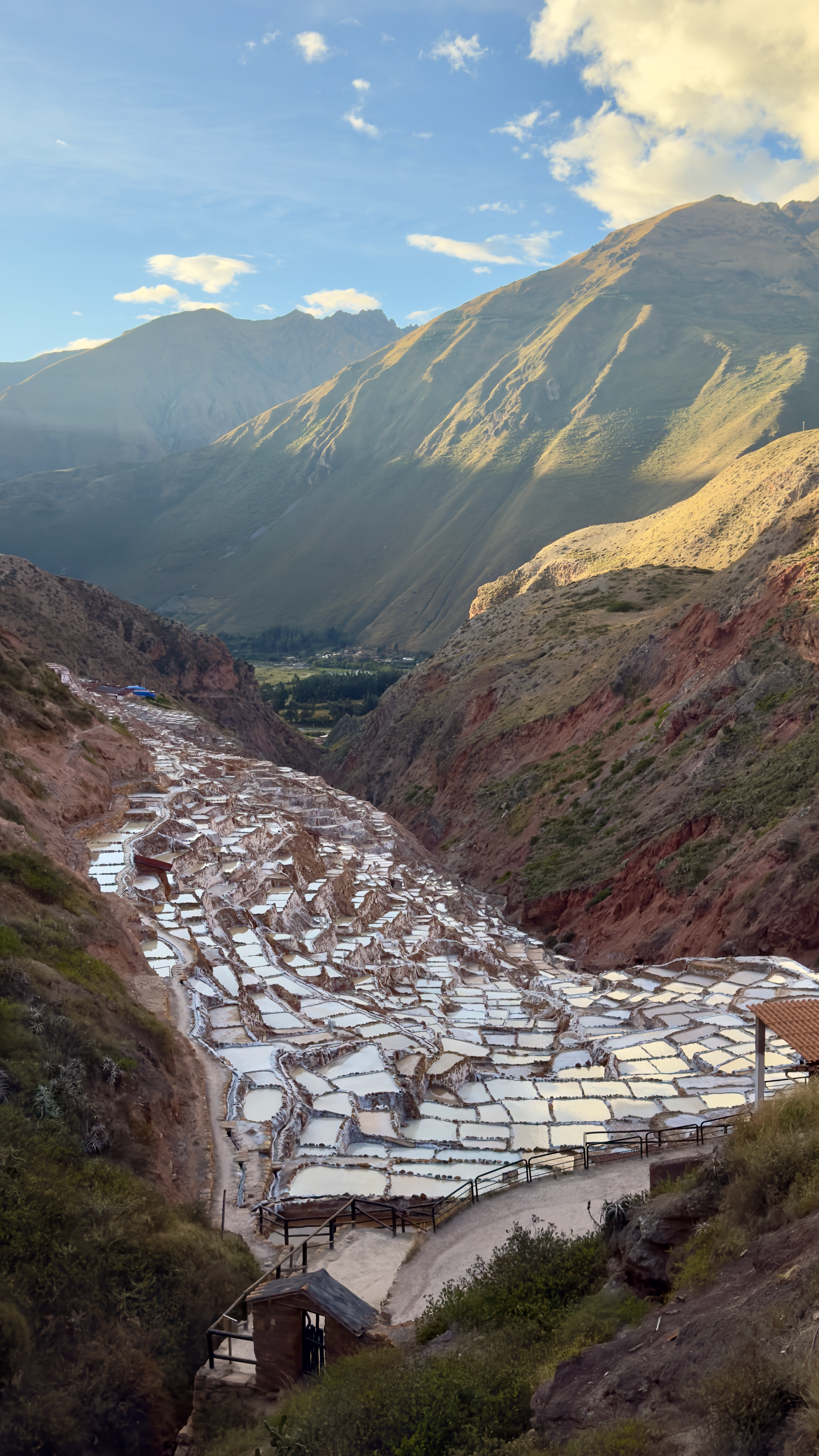 Cascading terraced salt evaporation pools carved into a mountainside in the Sacred Valley